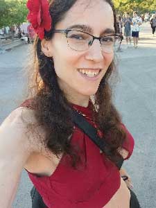 Alyssa Gonzalez in red top smiling at camera.