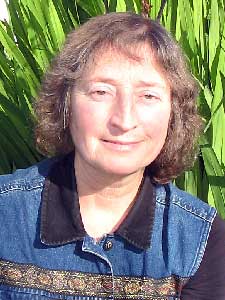 Kathy Labriola in collared shirt with plants in background.