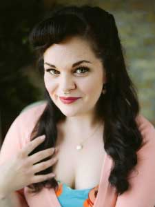 Lyndzi Miller in pink top with hand on hair.