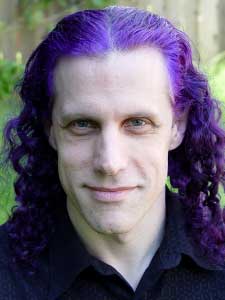 Pepper Mint with purple hair smiling at camera.