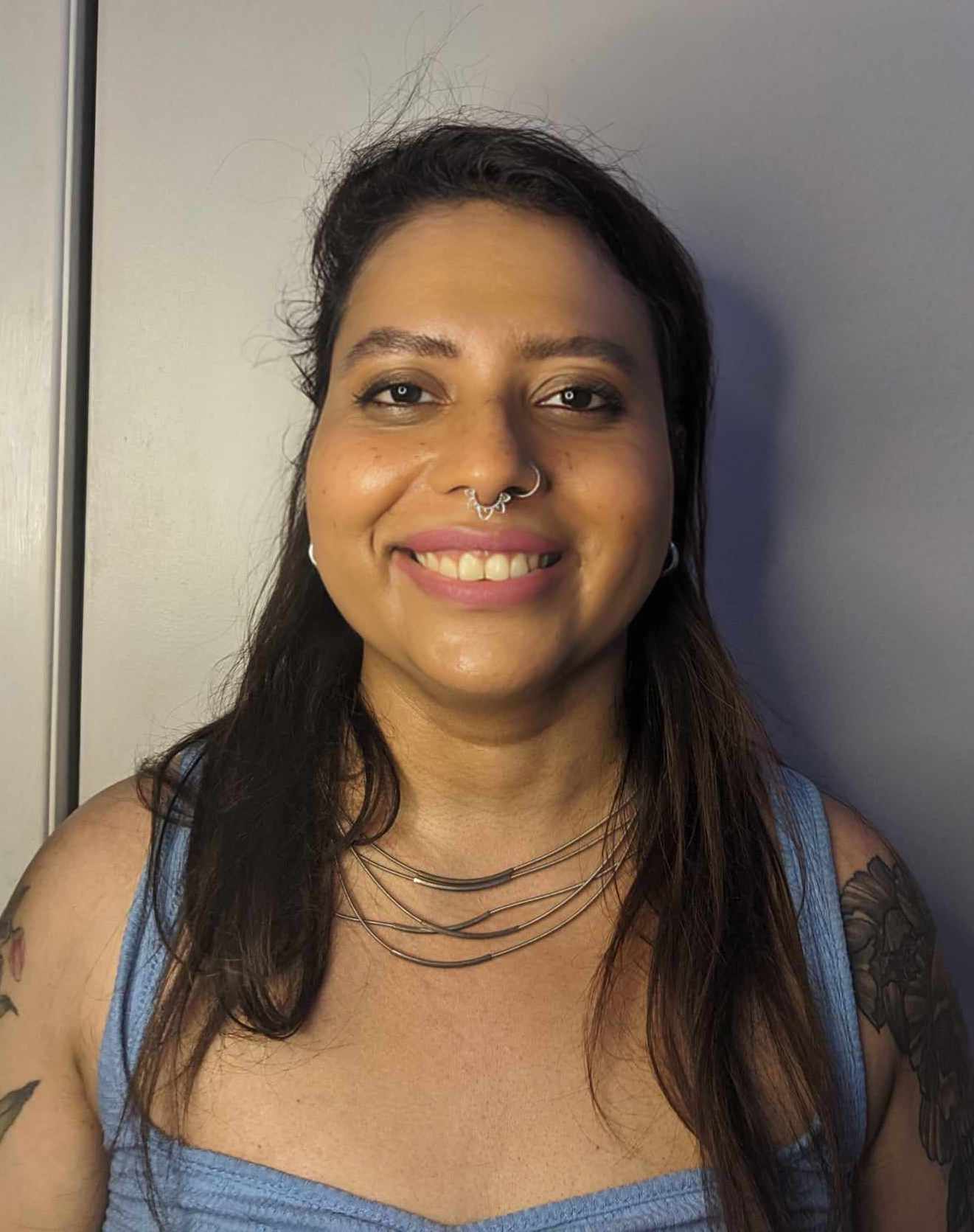 Zara Shah, author of Nonmonogamy and Sex Work, smiling in blue tank top.